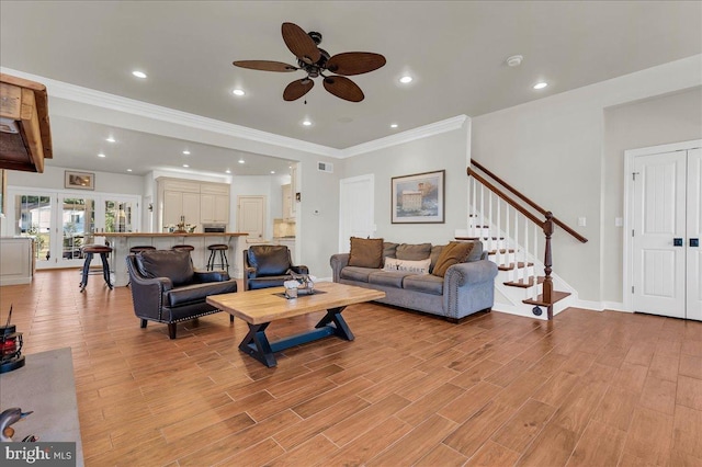 living room with visible vents, recessed lighting, stairs, and light wood-style floors