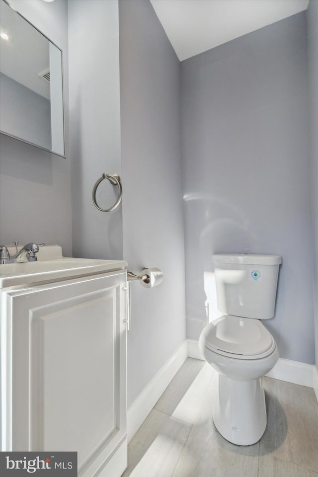 bathroom with vanity, toilet, and baseboards