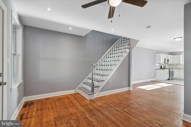 interior space featuring a ceiling fan, recessed lighting, wood finished floors, and baseboards