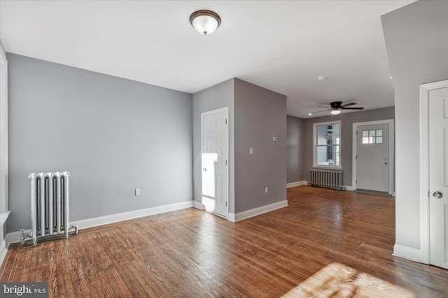 entrance foyer featuring radiator heating unit, baseboards, and wood finished floors