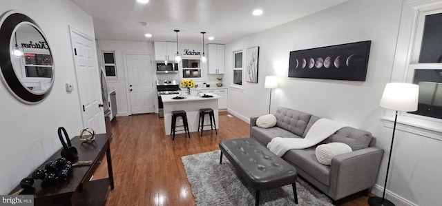 living area featuring recessed lighting, baseboards, and dark wood-type flooring