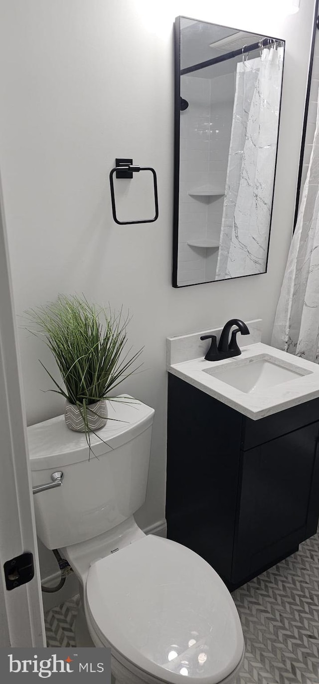 bathroom with a shower with curtain, toilet, and vanity