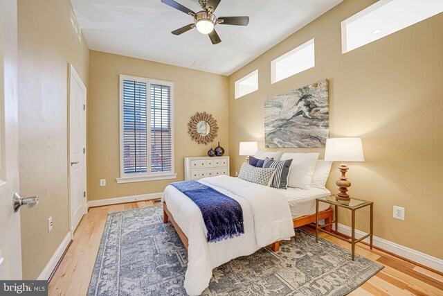 bedroom with a ceiling fan, baseboards, and wood finished floors