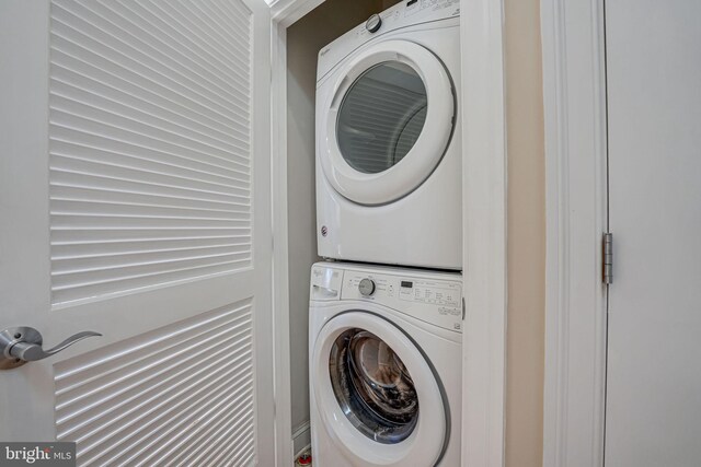 laundry room with stacked washer and clothes dryer and laundry area