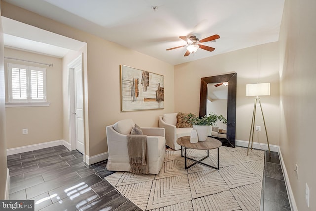 living room with wood finish floors, baseboards, and a ceiling fan