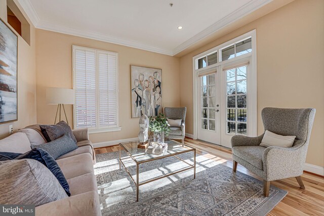 living area with a wealth of natural light, french doors, wood finished floors, and ornamental molding