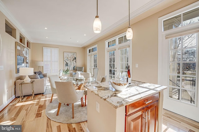 kitchen with light wood finished floors, recessed lighting, hanging light fixtures, crown molding, and open floor plan