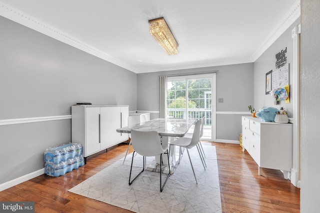 dining area with crown molding, baseboards, and hardwood / wood-style flooring