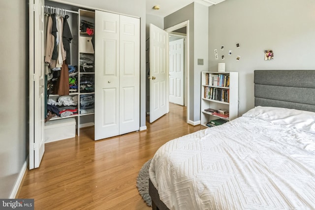 bedroom featuring a closet, baseboards, and wood finished floors