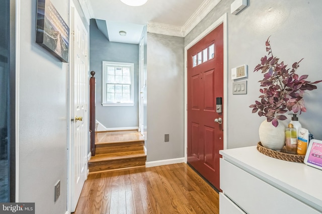 foyer entrance featuring stairway, baseboards, light wood-style floors, and ornamental molding