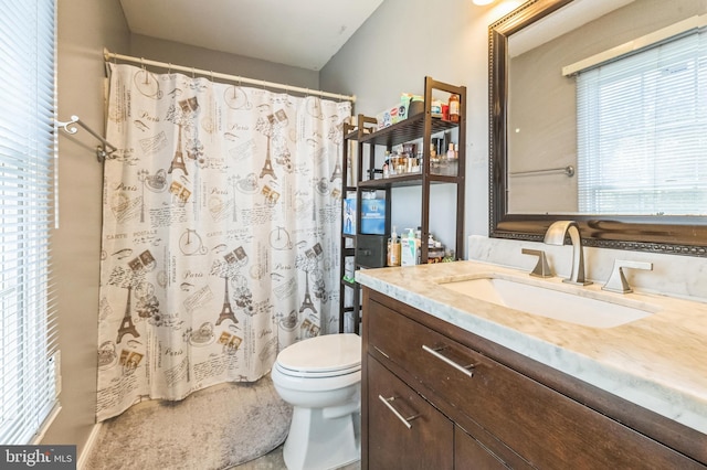 full bathroom featuring a shower with shower curtain, toilet, and vanity