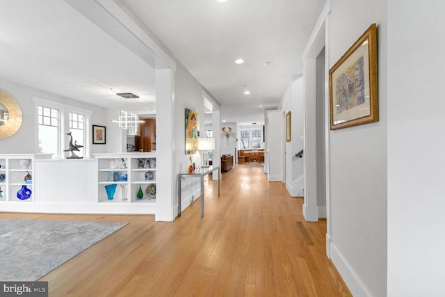 hall with recessed lighting, light wood-type flooring, and baseboards