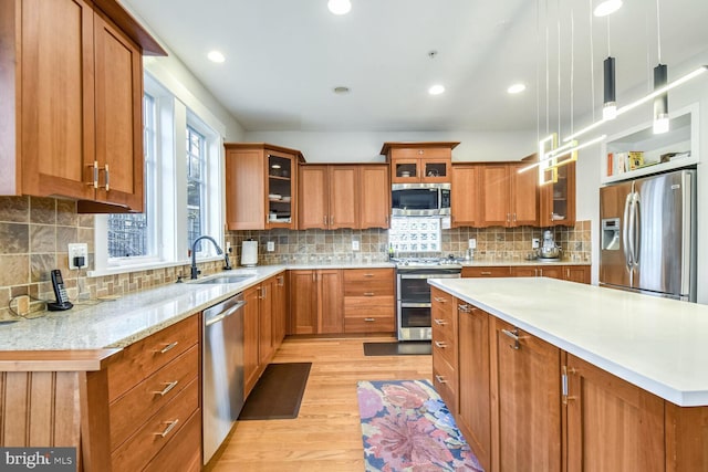 kitchen featuring brown cabinetry, stainless steel appliances, and a sink