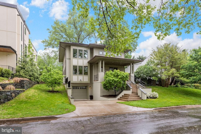 view of front of property featuring a front lawn, a garage, driveway, and stucco siding