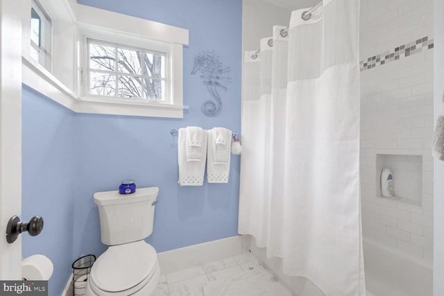 bathroom featuring baseboards, toilet, marble finish floor, and shower / tub combo