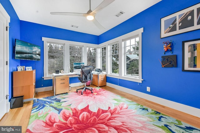 office featuring ceiling fan, visible vents, baseboards, and wood finished floors