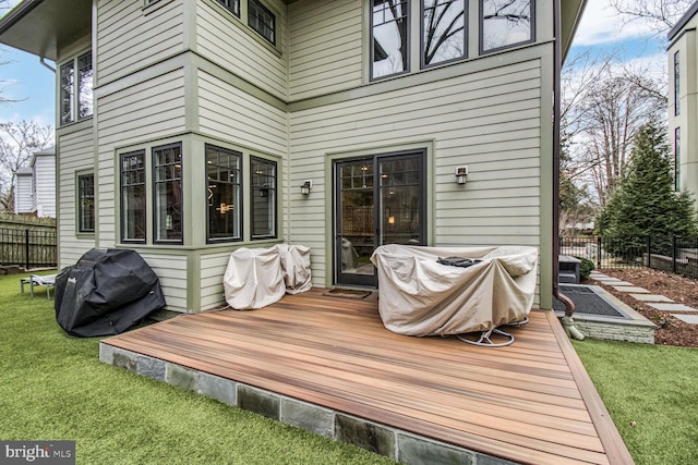 deck featuring a yard, a grill, and fence