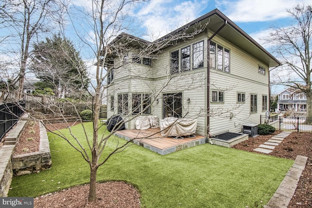 rear view of property featuring a lawn and a fenced backyard