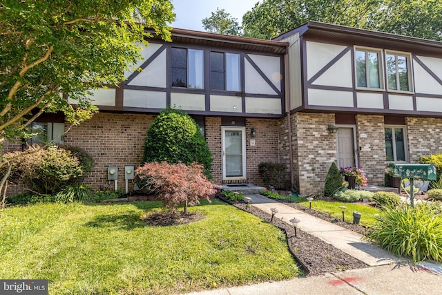 24 W Orange Ct, Baltimore, MD 21234 - tudor-style house with brick siding, a front lawn, and stucco siding