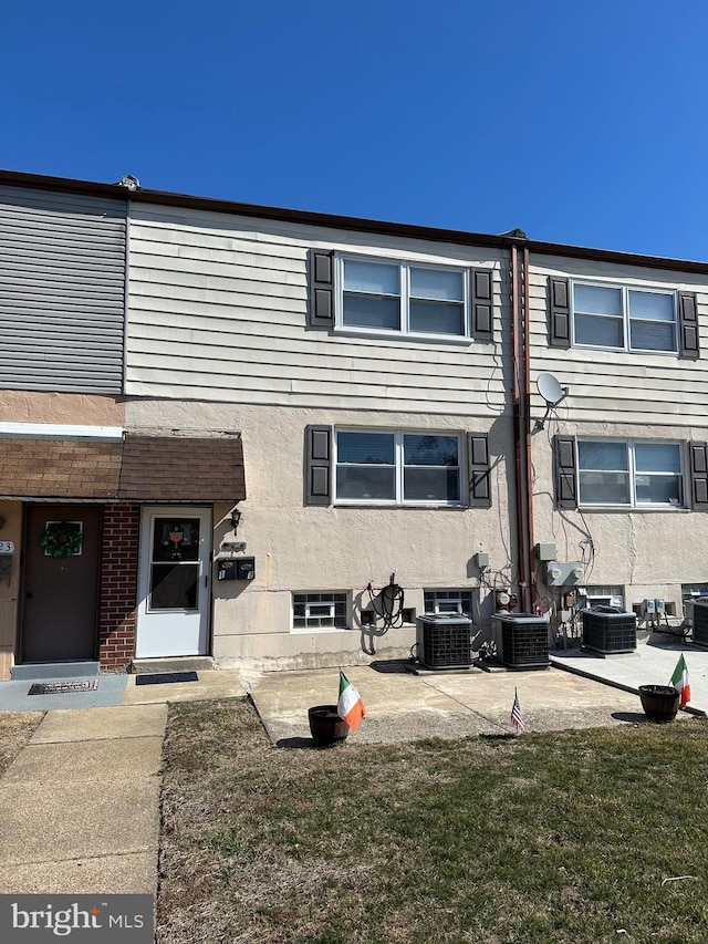 multi unit property featuring stucco siding, central AC unit, and a patio area