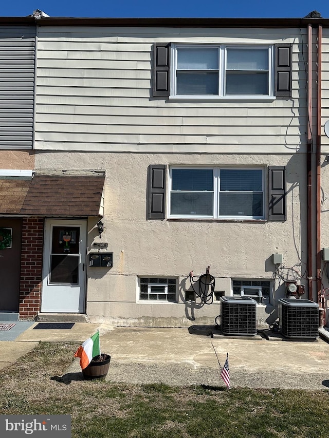 rear view of house featuring central air condition unit, a patio area, and stucco siding