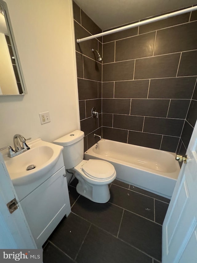 full bath featuring tub / shower combination, toilet, vanity, and tile patterned flooring