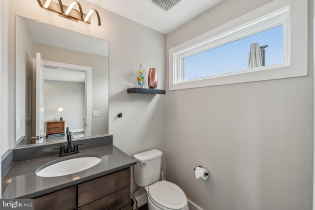 bathroom featuring vanity, toilet, and visible vents