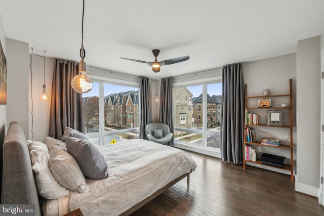 bedroom featuring dark wood finished floors, access to outside, a city view, and a ceiling fan