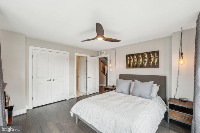 bedroom featuring visible vents, ceiling fan, baseboards, wood finished floors, and a closet