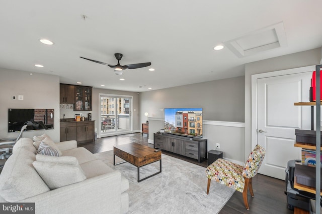 living room with attic access, recessed lighting, dark wood-style floors, and indoor bar