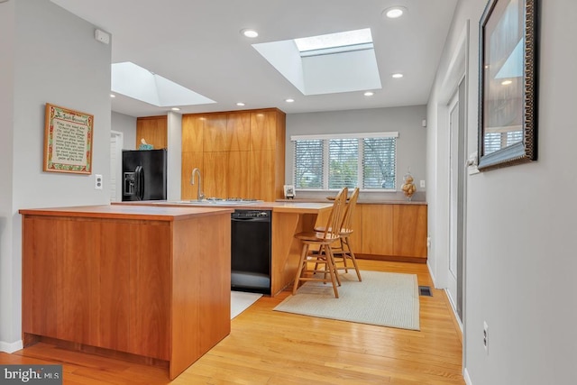 99 N Lakeshore, Manahawkin, NJ 08050 - kitchen with a peninsula, a skylight, black appliances, modern cabinets, and light wood-type flooring