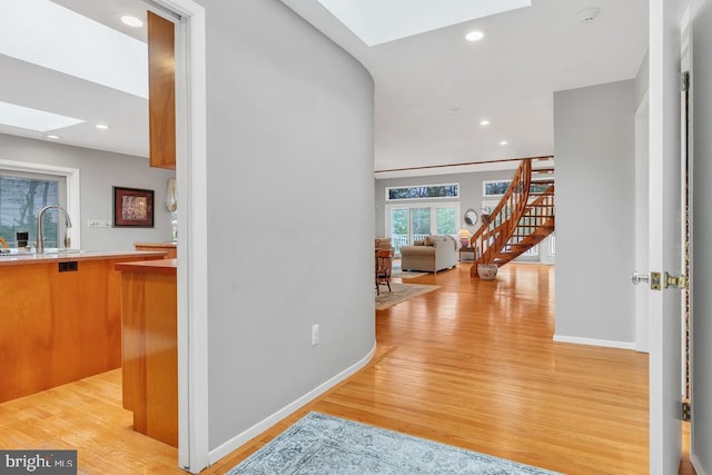 99 N Lakeshore, Manahawkin, NJ 08050 - hallway with a sink, a skylight, light wood finished floors, baseboards, and stairs
