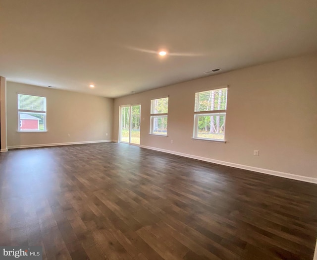 spare room with recessed lighting, baseboards, visible vents, and dark wood-style flooring