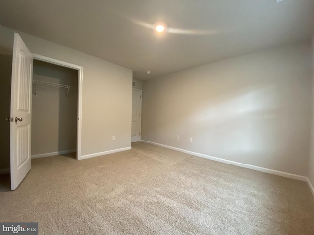 unfurnished bedroom featuring a closet, light colored carpet, and baseboards