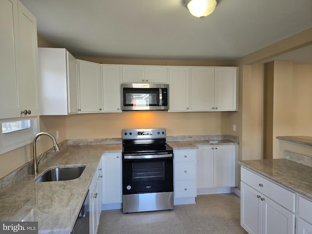 kitchen featuring a sink, white cabinets, light stone counters, and stainless steel appliances