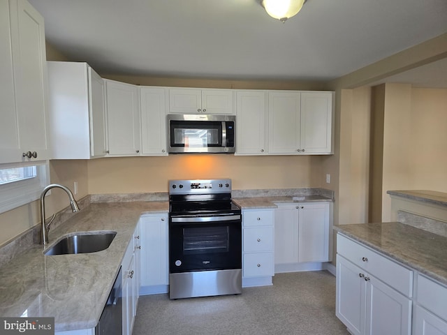 kitchen with a sink, appliances with stainless steel finishes, and white cabinetry