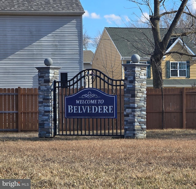 community / neighborhood sign featuring fence