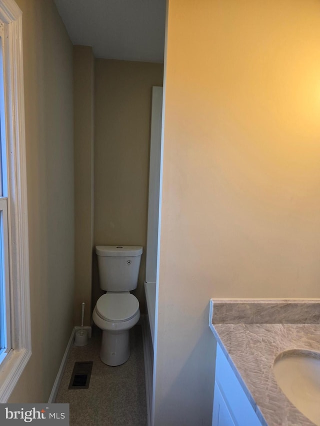 bathroom featuring visible vents, toilet, vanity, and baseboards