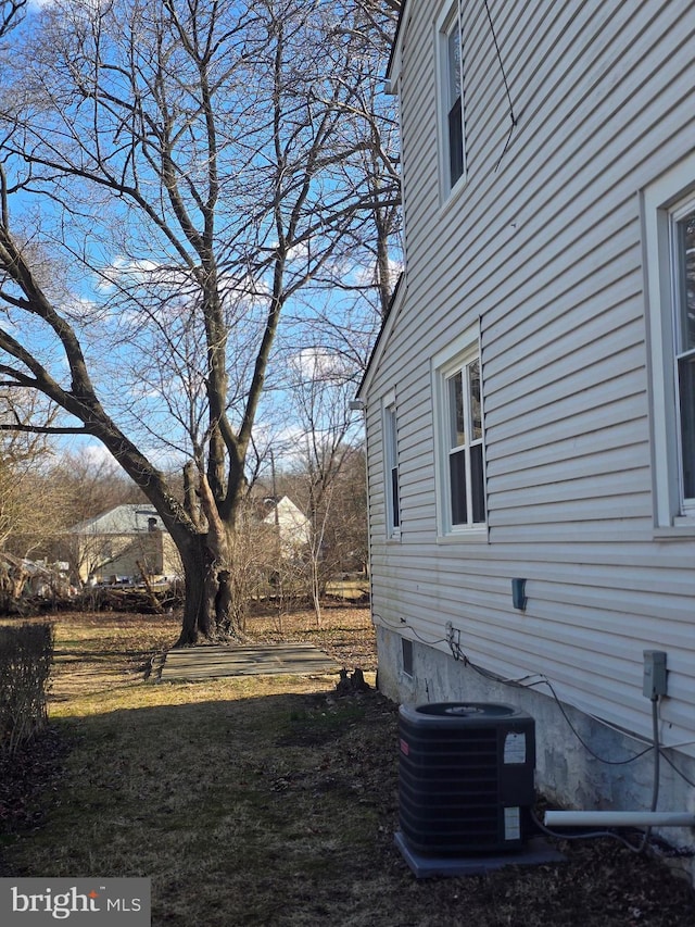 view of home's exterior featuring a lawn and central AC