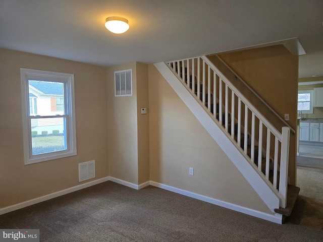 staircase with visible vents, baseboards, and carpet flooring