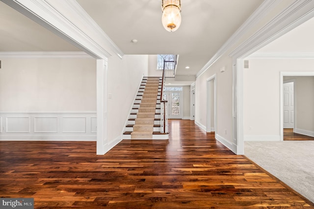 entrance foyer with wood finished floors, stairs, and ornamental molding