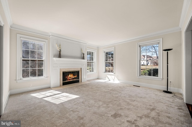 unfurnished living room with crown molding, carpet flooring, baseboards, and a premium fireplace