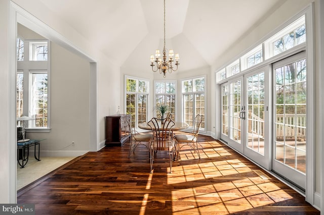 sunroom with lofted ceiling, a notable chandelier, and french doors