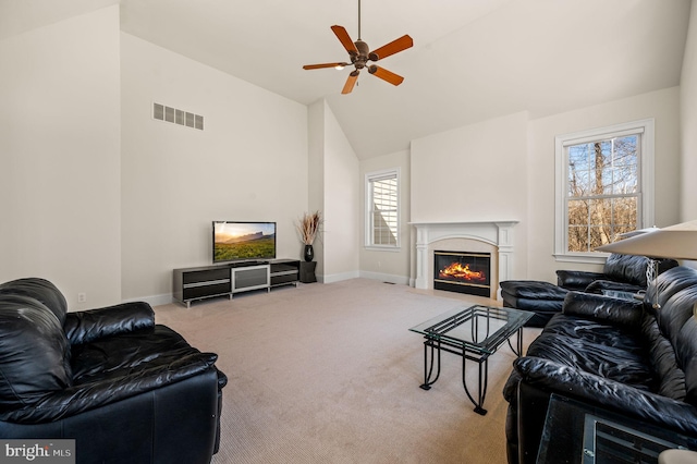 living room featuring visible vents, baseboards, a premium fireplace, carpet floors, and a ceiling fan