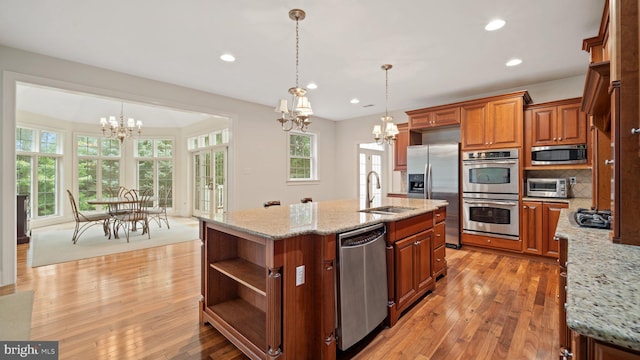 kitchen with open shelves, a sink, appliances with stainless steel finishes, a notable chandelier, and brown cabinets