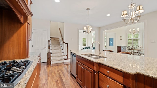 kitchen featuring a sink, black gas cooktop, light wood-style flooring, an inviting chandelier, and stainless steel dishwasher