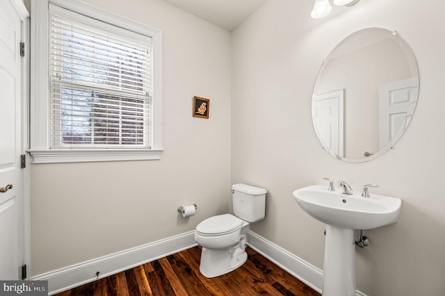 bathroom featuring toilet, baseboards, and wood finished floors