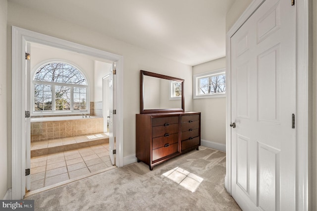 interior space featuring light colored carpet and baseboards