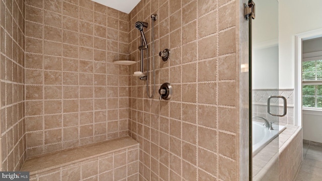 bathroom with a tile shower and tiled tub