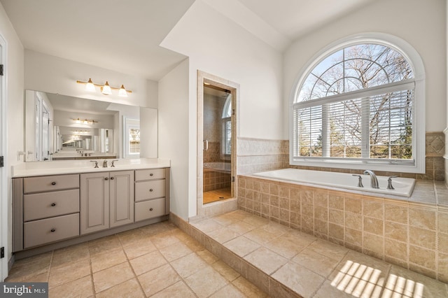 bathroom featuring a shower stall, vanity, a healthy amount of sunlight, and a garden tub